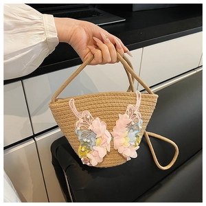 Detail der gewebten Stroh-Beuteltasche mit großem bunten Spitzen-Schmetterling und Perlen