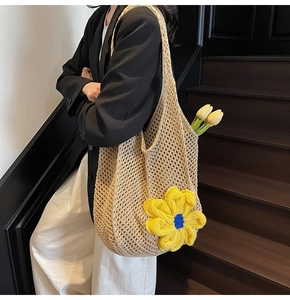 Detail of hand-woven hollow tote bag featuring a large yellow 3D crochet flower on the side