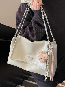 Minimalist cream soft leather tote bag with silver chain strap and bear pendant detail