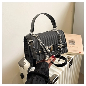 Détail du sac bandoulière noir avec breloque cœur argentée et bandoulière chaîne