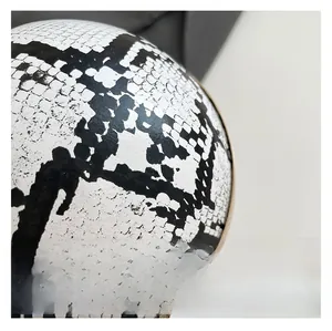 Macro shot of faux snakeskin texture and gold metal rim on the spherical handbag
