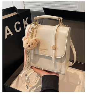 Close-up of beige structural backpack with crackle-effect PU leather and gold hardware
