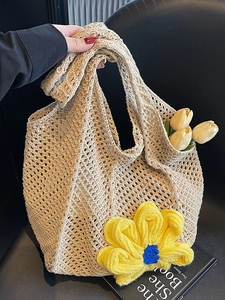 Beige woven tote bag with yellow knit flower charm and light rustic summer style
