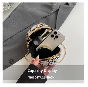Spherical snake skin bag interior showing capacity for phone, lipstick and compact
