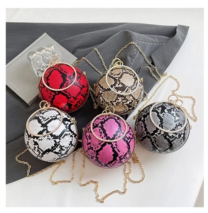 Detailed view of spherical snake pattern evening bags with diamond metal handles and gold chains