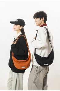 Détail des sacs demi-lune en nylon orange et noir portés par des modèles masculins et féminins