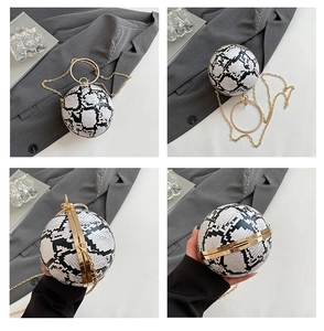 Detailed macro view of snakeskin pattern sphere bag with golden ring handle and chain