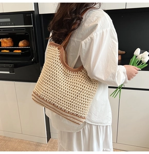 Detail of woven tote bag with brown leather straps and mesh pattern in modern kitchen