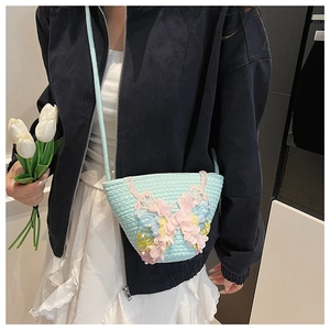 Detail der hellblauen geflochtenen Beuteltasche mit 3D-Schmetterling und Perlen