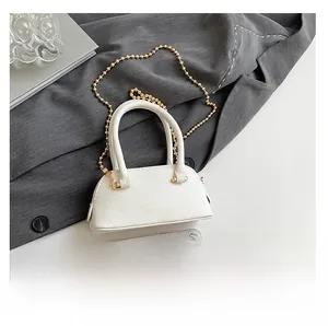 Detail of white litchi pattern leather shell bag with gold chain and phone size comparison