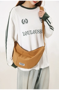 Détail d'un sac demi-lune en nylon caramel avec étiquette de marque et bandoulière