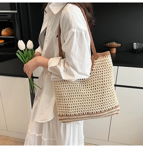 Detail view of woven tote bag with hollow mesh pattern and brown leather straps