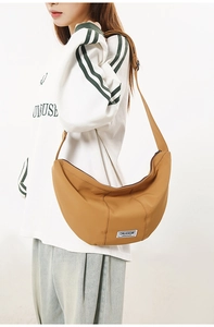 Détail du sac croissant en nylon kaki avec étiquette de marque et bandoulière réglable