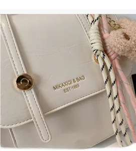 Detail of soft cream leather backpack with braided rope and plush bear charm