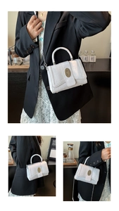 Detailed close-up of white crocodile pattern texture and gold buckle on the handbag