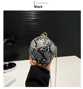 Detail of snake pattern texture on black and white spherical bag with gold chain strap
