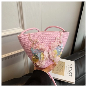 Detailaufnahme der rosa geflochtenen Beuteltasche mit 3D-Schmetterling und Perlenverzierung