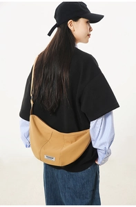 Détail du sac demi-lune en nylon kaki avec bandoulière réglable et style décontracté