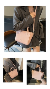 Detail view of pink woven leather bucket bag with top handles and adjustable shoulder strap