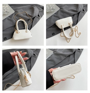 Detail view of white lychee-patterned shell bag with gold bead chain and top zipper