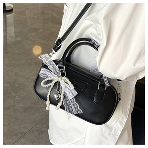 Détail du sac bowling noir avec nœud en perles, dentelle et foulard élégant