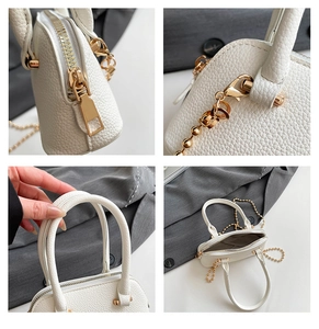 Close-up of white shell bag showing lychee grain texture and gold chain hardware