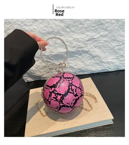 Close-up of rose red snakeskin spherical handbag with diamond-encrusted metal handle