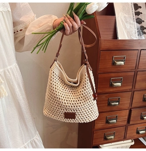 Close-up of bohemian woven tote bag showing detailed crochet pattern and leather strap buckle
