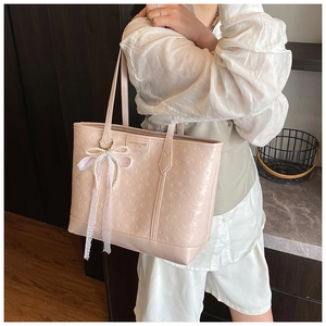 Close-up of pink tote bag featuring heart floral embossing and lace pearl bow detail