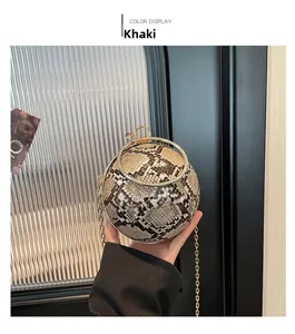 Macro detail of khaki snakeskin spherical bag with sparkling rhinestone metal ring handle