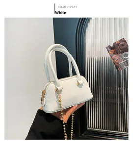 Detail of white mini shell handbag with pebble grain leather and golden chain strap