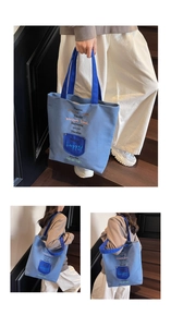 Detail of blue canvas tote bag showing embroidered days and a navy contrast front pocket