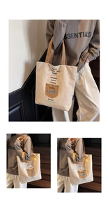 Detail of canvas tote bag showing colorful graphic text and brown patch pocket design