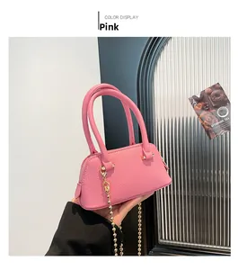 Detail of pink shell-shaped bag with lychee grain texture and gold chain strap