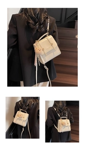 Detail view of cream mini backpack with crocodile pattern and bear plush charm accessory