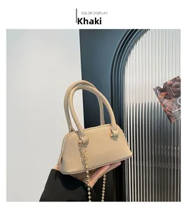 Detail of khaki shell bag with lychee pattern leather and golden beaded chain strap
