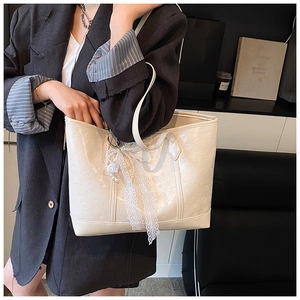 Detail of cream white tote bag with embossed texture and lace pearl floral charms