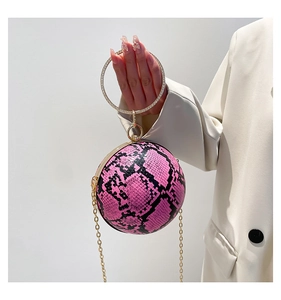 Detailed view of spherical snake pattern evening bag with rhinestone ring handle and chain