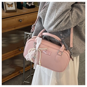 Sac bowling rose avec nœud perlé et rubans en dentelle dans un cadre lifestyle chic