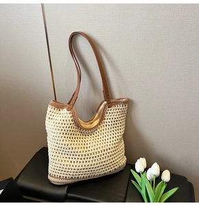 Detailed close-up of woven straw tote bag with brown leather handles and beige mesh texture