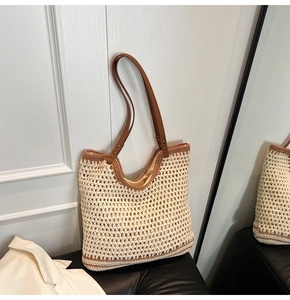Detail of hollow-out crochet pattern and brown faux leather strap on woven tote bag