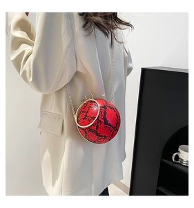 Detailed back view of a red snakeskin sphere bag with a sparkling diamond handle