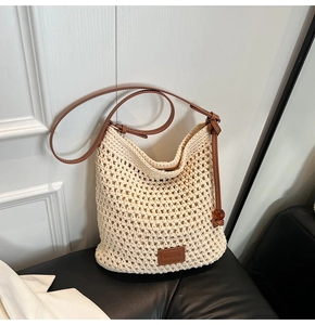 Detail view of woven bucket bag with adjustable leather strap and drawstring closure