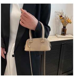 Detail of beige lychee leather mini shell bag with golden bead chain strap