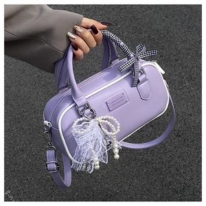 Détail du sac Boston lavande avec passepoil blanc et poignée enveloppée d'un ruban élégant