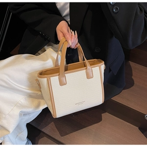 Close-up of woven tote bag with brown leather trim and MIKAXIQI branding logo