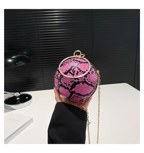 Close-up of pink and black snakeskin sphere bag with gold diamond-set ring handle