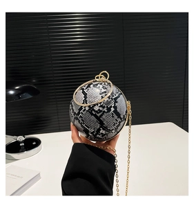 Detail of spherical snakeskin evening bag with gold ring handle and chain strap
