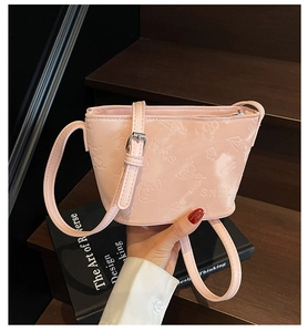 Gros plan sur le cuir synthétique rose gaufré avec motifs de papillons et zip argenté