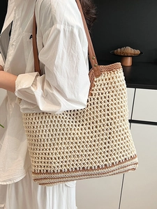 Minimalist beige woven tote bag with brown leather straps for a stylish summer vacation